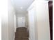 Welcoming hallway with tiled floors, neutral paint, white trim, and a closet at 1721 Sandalwood Sw Cir, Winter Haven, FL 33880