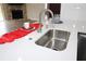 Close up of a stainless steel kitchen sink with white countertops and modern faucet fixture at 1721 Sandalwood Sw Cir, Winter Haven, FL 33880