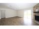 Open-plan living room featuring wood-look floors, stone fireplace, and sliding glass doors to the backyard at 1721 Sandalwood Sw Cir, Winter Haven, FL 33880