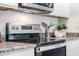 Stainless steel oven sits below the range hood among granite countertops and white cabinets at 177 Highland Dr, Deltona, FL 32738