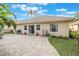 Paver patio and manicured lawn in a private backyard featuring mature landscaping and grill at 204 Lake Region S Blvd, Winter Haven, FL 33881