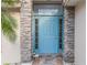 Close-up of a charming blue front door with stone accents and decorative welcome mat at 204 Lake Region S Blvd, Winter Haven, FL 33881