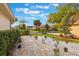 Landscaped walkway and garden beds leading to a yellow home with mature trees and lush greenery at 204 Lake Region S Blvd, Winter Haven, FL 33881