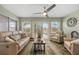 Cozy living room features comfortable seating, ceiling fan, and sliding glass doors to the outdoor patio at 204 Lake Region S Blvd, Winter Haven, FL 33881