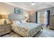 Bright main bedroom with tray ceilings, a patterned comforter, and ample natural light at 204 Lake Region S Blvd, Winter Haven, FL 33881