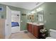 Bathroom with dual sinks, cherry wood cabinets, tile flooring, and green painted walls at 2040 Touchwood Ct, Apopka, FL 32712