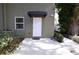 The home's backdoor with a black awning, a security camera, and a small patio at 210 N East St, Maitland, FL 32751