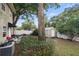 Backyard featuring a shed, mature trees, white fence, and patio area at 210 N East St, Maitland, FL 32751