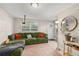 Inviting living room with a green sectional sofa, a projector, and a round mirror at 210 N East St, Maitland, FL 32751