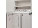 Convenient laundry room with white washer and dryer units and shelving at 225 Ranier Cv # 105, Casselberry, FL 32707