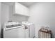 Bright laundry room with white cabinets, modern washer and dryer, and decorative accents at 2273 Lost Horizon Way, Clermont, FL 34715