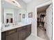 Bathroom with a vanity and marble countertop, mirror, and a view to walk-in closet at 2348 Clemblue Rd, Clermont, FL 34715