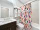 Bathroom featuring a sink with dark wood vanity, toilet, and bathtub with decorative shower curtain at 2348 Clemblue Rd, Clermont, FL 34715