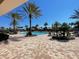 Community pool featuring cabanas, lounge chairs, and palm trees under a clear blue sky at 2348 Clemblue Rd, Clermont, FL 34715