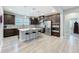 Modern kitchen with dark wood cabinetry, stainless steel appliances, and a marble countertop island with stylish seating at 2348 Clemblue Rd, Clermont, FL 34715