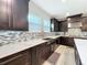 Kitchen with stainless steel farmhouse sink, custom backsplash, and dark wood cabinets under bright windows at 2348 Clemblue Rd, Clermont, FL 34715