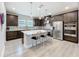 Modern kitchen with dark wood cabinetry, stainless steel appliances, and a marble countertop island with stylish seating at 2348 Clemblue Rd, Clermont, FL 34715