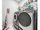 Well-equipped laundry room with front loading washer and dryer, storage shelves, and modern design at 2348 Clemblue Rd, Clermont, FL 34715