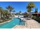 Lazy river and community pool, featuring tropical landscaping and lounge chairs under a clear blue sky at 2348 Clemblue Rd, Clermont, FL 34715