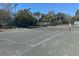 Tennis court with a green and gray surface and a net surrounded by a fence at 2348 Clemblue Rd, Clermont, FL 34715