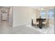 Bright dining room with a black table, 6 beige chairs, tile floor, and a gray and white rug at 2930 Wordsmith Rd, Kissimmee, FL 34746