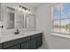 Bathroom vanity with double mirrors and dark cabinets, bright natural light, and modern hardware at 3000 Stonington Run, Kissimmee, FL 34746