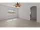 Bright bedroom boasting hardwood floors, neutral paint, a fan, and an open doorway to the ensuite bathroom at 3000 Stonington Run, Kissimmee, FL 34746