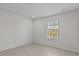 Bright bedroom featuring a window, light wood floors, and fresh white paint at 3000 Stonington Run, Kissimmee, FL 34746