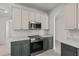 A kitchen with modern stainless steel appliances and gray cabinets, showcasing a sleek design at 3000 Stonington Run, Kissimmee, FL 34746