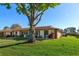 Well-maintained single-story home showcasing a lush green lawn and mature shade tree at 30113 Robin Ln, Tavares, FL 32778