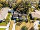 Aerial view of home with mature trees and landscaping, long driveway and nearby homes at 303 S Forest Ave, Orlando, FL 32803