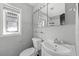 Cozy bathroom featuring vanity, toilet, window for natural light, and medicine cabinet above the sink at 303 S Forest Ave, Orlando, FL 32803