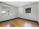 Bedroom showcasing hardwood flooring, two windows for natural light, and neutral wall paint at 303 S Forest Ave, Orlando, FL 32803