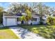 Charming single-story home with a well-manicured lawn, mature landscaping, and a classic blue door at 303 S Forest Ave, Orlando, FL 32803