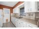 Cozy kitchen featuring stainless steel sink, white cabinets, tiled backsplash, and tiled flooring at 303 S Forest Ave, Orlando, FL 32803