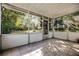 Screened in porch features tiled flooring and views of the landscaped backyard and mature trees at 303 S Forest Ave, Orlando, FL 32803