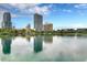 Picturesque waterfront view reflecting skyscrapers, lush greenery, and a rainbow sculpture at 303 S Forest Ave, Orlando, FL 32803