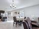 Open dining area featuring tile flooring and a modern chandelier, adjacent to the kitchen at 3088 Prelude Ln, Kissimmee, FL 34746