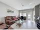 Comfortable living room featuring a brown leather couch and a decorative glass coffee table at 3088 Prelude Ln, Kissimmee, FL 34746