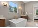 Spa-like bathroom features a freestanding tub, large window, and modern lighting at 3135 Vanguard Ct, St Cloud, FL 34771