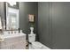 Stylish powder room featuring gray walls, toilet with artistic statue decor, and a marble-top vanity at 3135 Vanguard Ct, St Cloud, FL 34771