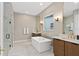 Elegant primary bathroom with freestanding tub, double vanity, and marble-style tile at 3135 Vanguard Ct, St Cloud, FL 34771