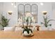 Bright dining room highlighting a wooden table centerpiece and trio of mirrors above a stylish sideboard at 3135 Vanguard Ct, St Cloud, FL 34771