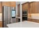 Bright kitchen with a stainless smart fridge, quartz countertops, and wood cabinetry at 3135 Vanguard Ct, St Cloud, FL 34771