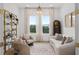 Bright living room featuring plush seating, a large window with sheer curtains, and a glass shelved display at 3135 Vanguard Ct, St Cloud, FL 34771