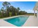 Backyard pool with a jacuzzi, dining table, and tropical plants surrounded by a black metal fence at 3135 Vanguard Ct, St Cloud, FL 34771