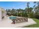 Backyard pool and patio with a dining table and chairs illuminated by string lights at 3135 Vanguard Ct, St Cloud, FL 34771