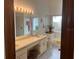 Bathroom showcasing a dual-sink vanity, a toilet, a bathtub, and a well-lit mirror with vanity lights at 3210 Little Oak Way, Orlando, FL 32812