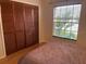 Bedroom with window providing lots of natural light, closet with wood doors, and hardwood floors at 3210 Little Oak Way, Orlando, FL 32812