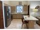 Well-lit kitchen with stainless steel refrigerator and center island with eat-in counter at 3210 Little Oak Way, Orlando, FL 32812